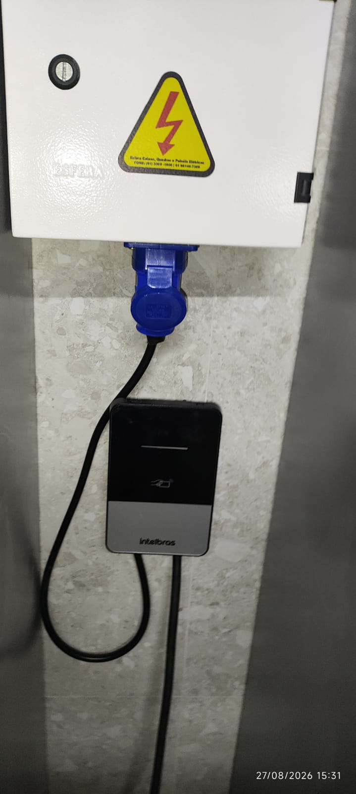 Caixa de proteção ligada ao carregador Intelbras em operação.